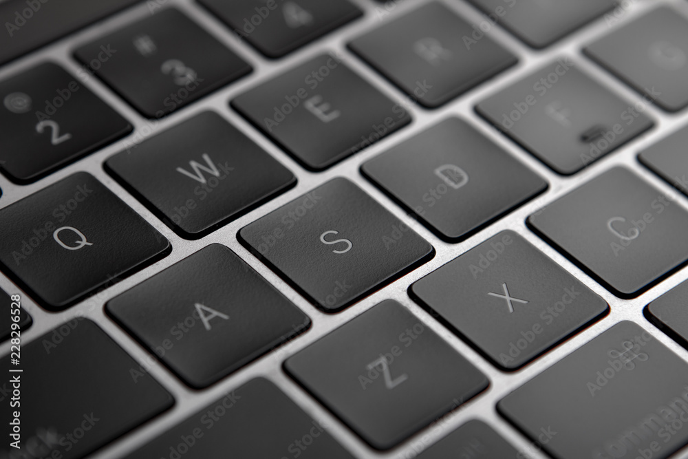 Black flat laptop keyboard close up.