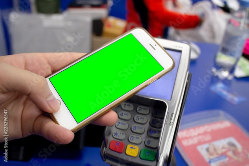 Paying with mobile phone at shop.