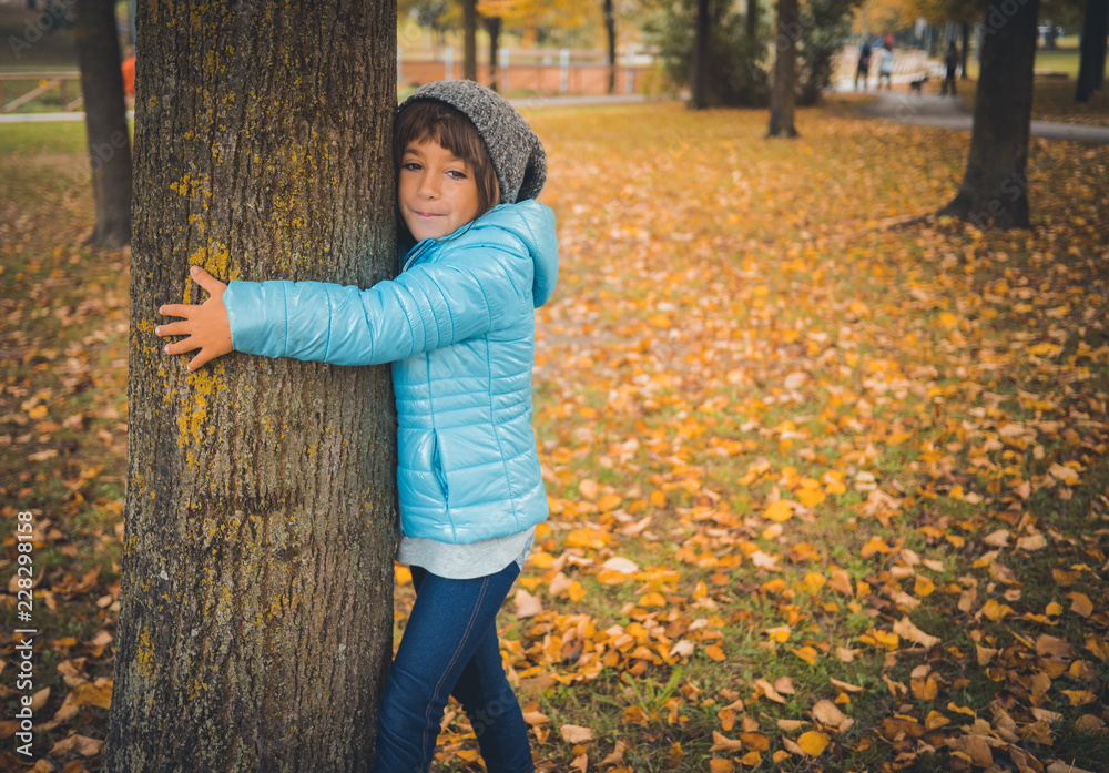 Portrait of six years old caucasian girl in autumn. She's wearing a ...