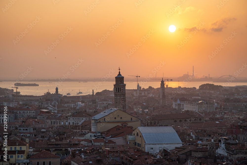 Venice city view from height. Houses roofs and sky at the sunset. Warm colors. Tilt-shift Venice city view from height. Houses roofs and sky at the sunset. Warm colors. Tilt-shift
