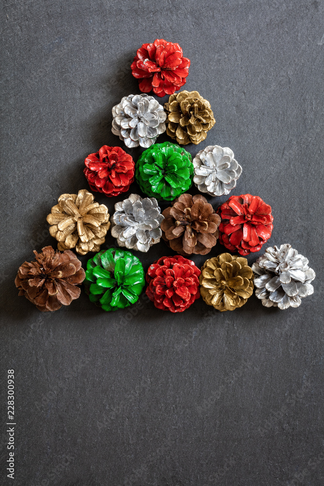 Christmas tree made out od colourful pine cones on dark background, top view Christmas tree made out od colourful pine cones on dark background, top view