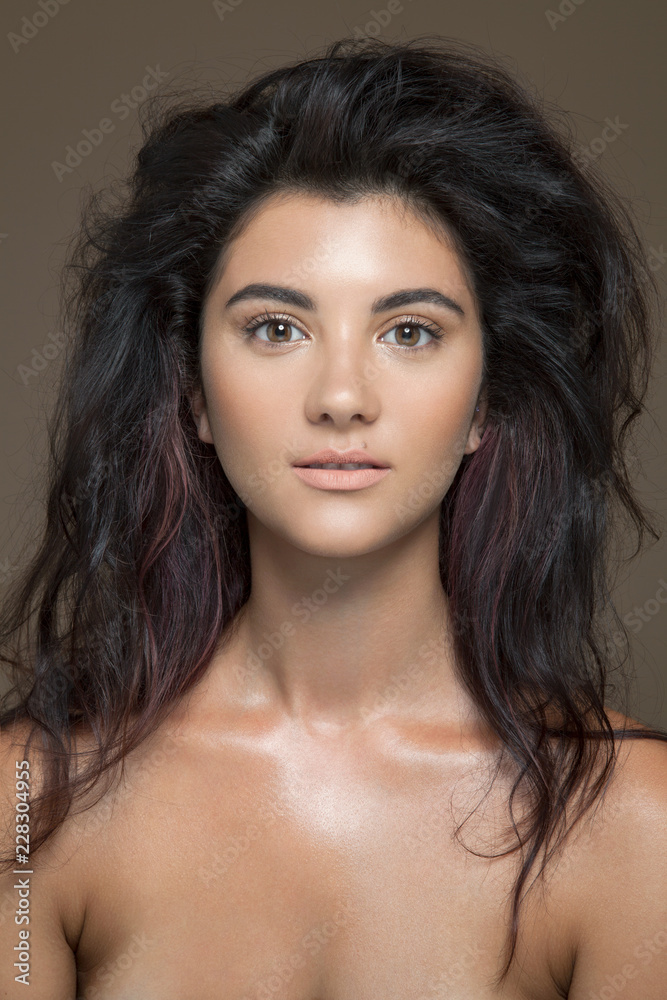 Portrait of a bare young woman with long, brown hair and natural