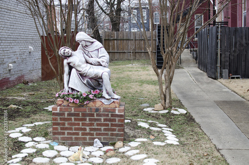 Statue in courtyard by Catholic Church Of Mary holding Jesus.