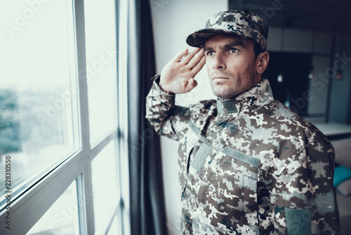 Portrait of Military Uniform Salute Near Window photo