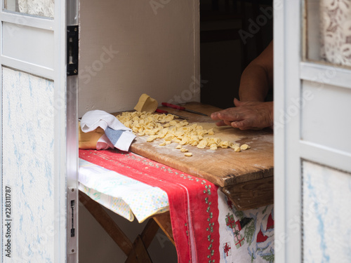 Homemade traditional pasta (orecchiette) on a wooden board. Bari, Italy. Tasty food concept