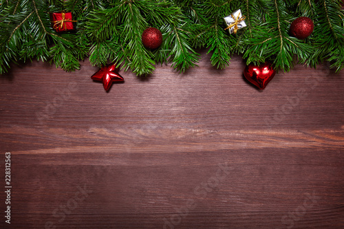 Christmas decorations, spruce branches and gifts on wooden surface.