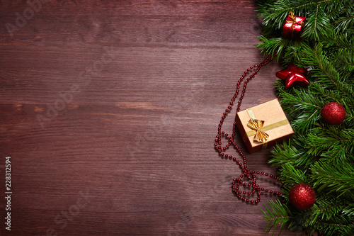 Christmas decorations, spruce branches and gifts on wooden surface.