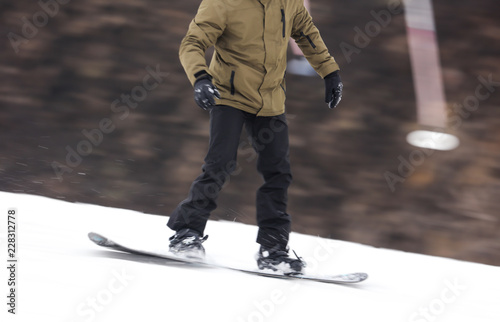 A guy is riding a snowboard from a mountain in winter