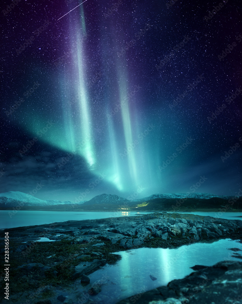 A spectacular Northern Light Aurora display lighting up the night sky in Northern Norway. A popular destination within the arctic circle for hunting the Northern Lights. Photo Composite.