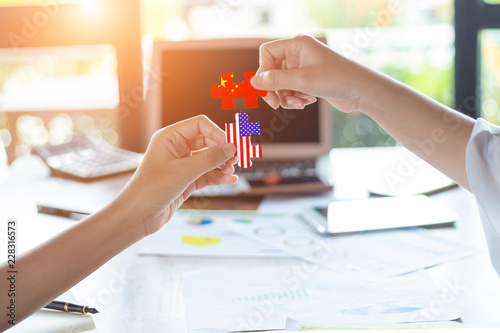 Two businesswoman connecting elements of China and the USA jigsaw puzzle