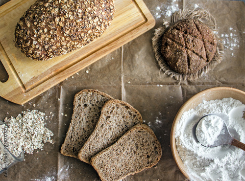  Bread of different types from flax, oat, rajoy flour on pergametny paper. The range of bread. Different types of grain bread, flour, oatmeal on parchment paper,  view from above photo