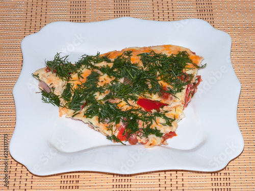 Fried eggs with tomatoes, fennel and sausage on a white plate