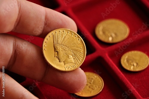 Numismatic at work shows some gold coins. Accessories are visible in the background. photo