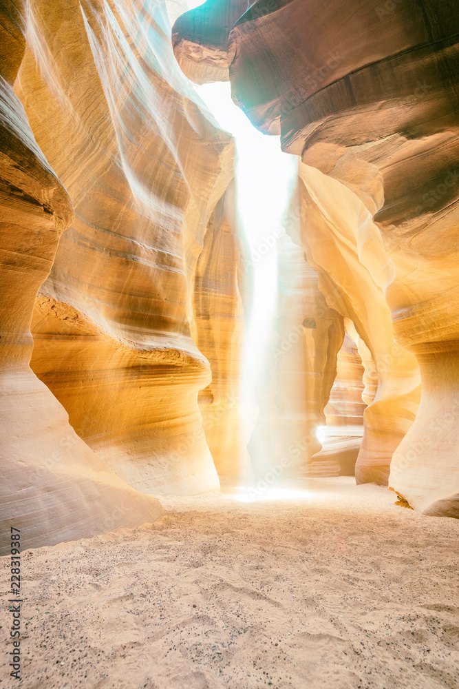 Beam of sand is flowing off the rocks in the interior of the narrow walls of the winding Antelope Canyon, Arizona