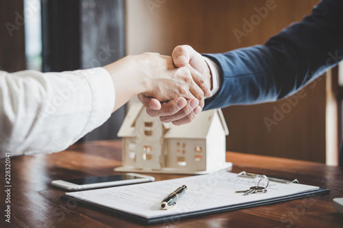 Estate agent and customer shaking hands after finished contract after about home insurance and investment loan photo