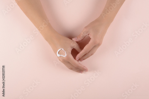 Skin care concept. Woman applying hand cream on puffy background. Flat lay. Top view
