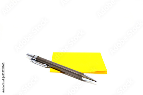 Yellow note pad and pen placed on a white background.