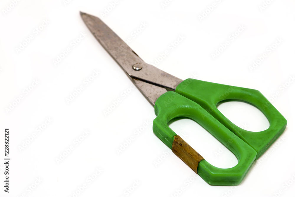 Green plastic handle scissors on white floor Green plastic handle scissors on white floor