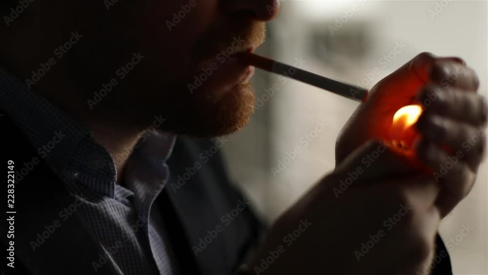 Attractive man with glasses smoking cigarette. Silhouette, slow motion