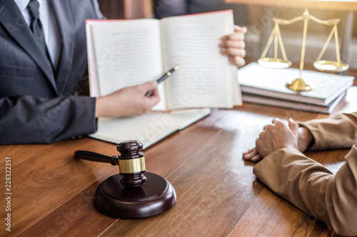 Obraz na plátně Judge gavel with scales of justice, Businesswoman and male lawyers or counselor discussing contract papers at law firm in office
