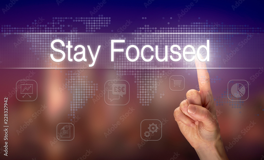 A hand selecting a Stay Focused business concept on a clear screen with a colorful blurred background. A hand selecting a Stay Focused business concept on a clear screen with a colorful blurred background.