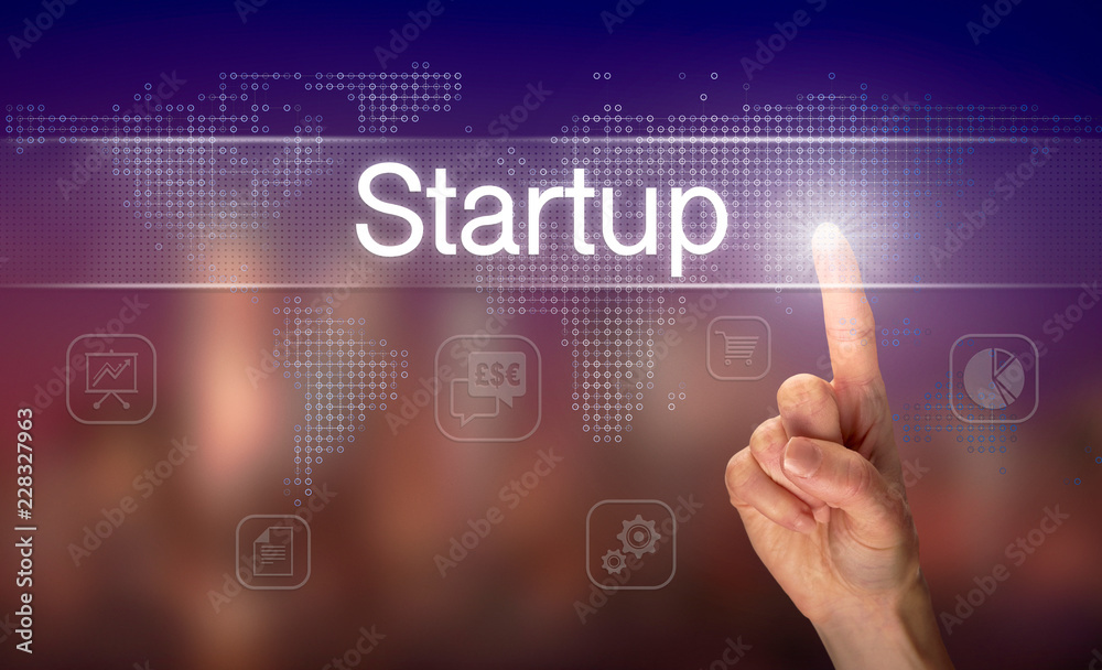 A hand selecting a Startup business concept on a clear screen with a colorful blurred background.