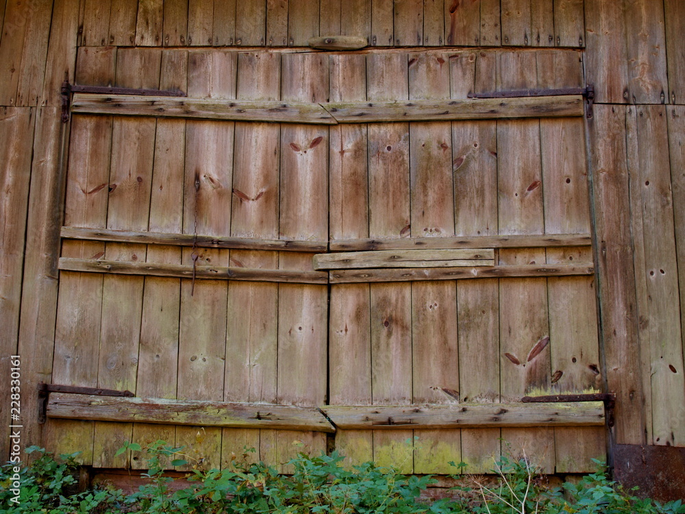 Large wooden doors of the old barn with iron canopies Large wooden doors of the old barn with iron canopies
