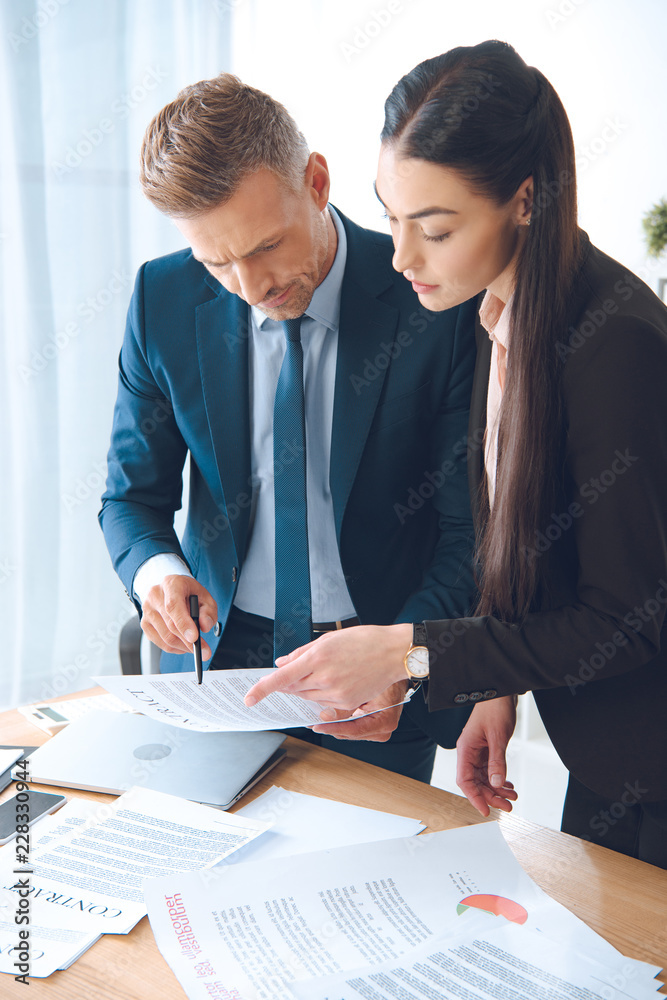 focused business colleagues doing paperwork at workplace in office focused business colleagues doing paperwork at workplace in office