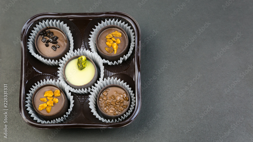 Five chocolates on a colored background. Candy with different fillings in a package of 5 pieces. Five chocolates on a colored background. Candy with different fillings in a package of 5 pieces.