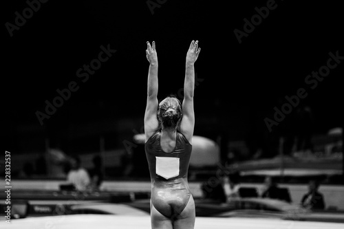 back female gymnast beginning of performing black-and-white photo