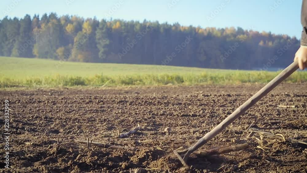 The farmer handles the land with a hoe The farmer handles the land with a hoe