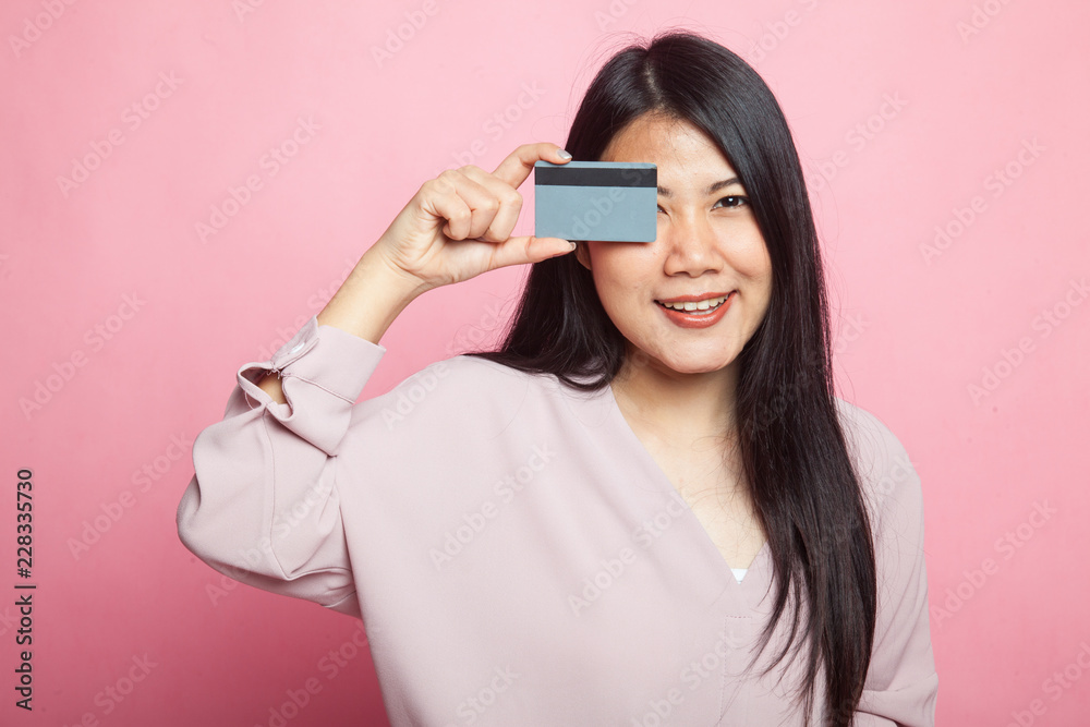 Young Asian woman with blank card over her eye. Young Asian woman with blank card over her eye.