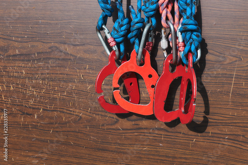 red carabines at scratched wood background. climbing safety system equipment photo