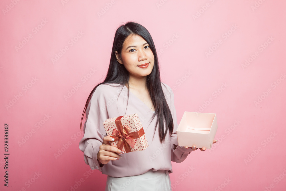 Young Asian woman open a golden gift box.