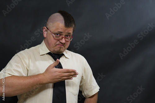 Punk. Sight over the glasses. White shirt, dark tie. On the face, an expression of indignation.