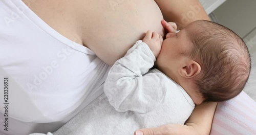 Young mother breastfeeding her newborn baby son. Happy mom hugging her babyboy close-up. Breast feeding and lactation infant concept.