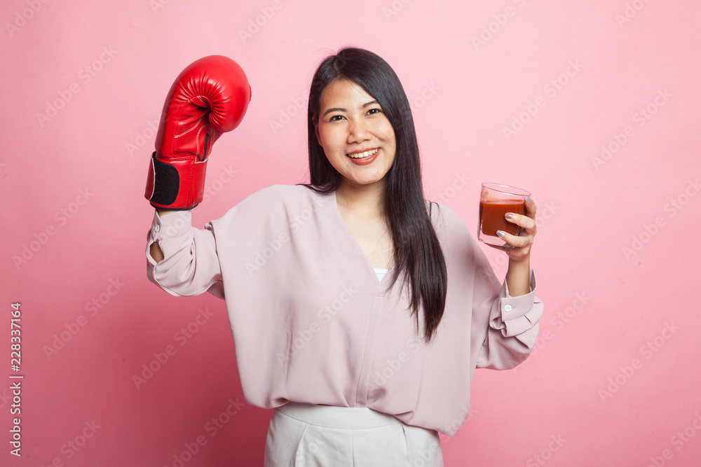 Young Asian woman with tomato juice and boxing glove. Young Asian woman with tomato juice and boxing glove.