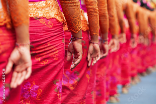 Group of beautiful Balinese women in costumes - sarong, carry offering for Hindu ceremony. Traditional dances, arts festivals, culture of Bali island and Indonesia people. Indonesian travel background