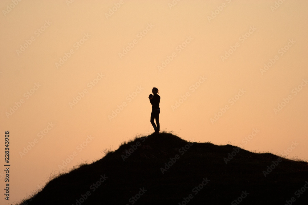 silhouette of woman on top of the mountain