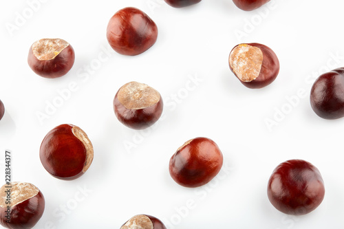 Many peeled chestnuts lie on white background