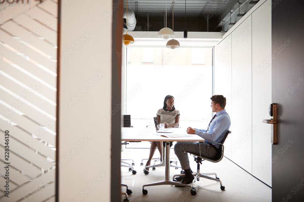 © Monkey Business - Businessman And Businesswoman Having Discussion Around Boardroom Table Viewed Through Meeting Room Door © Monkey Business - Businessman And Businesswoman Having Discussion Around Boardroom Table Viewed Through Meeting Room Door