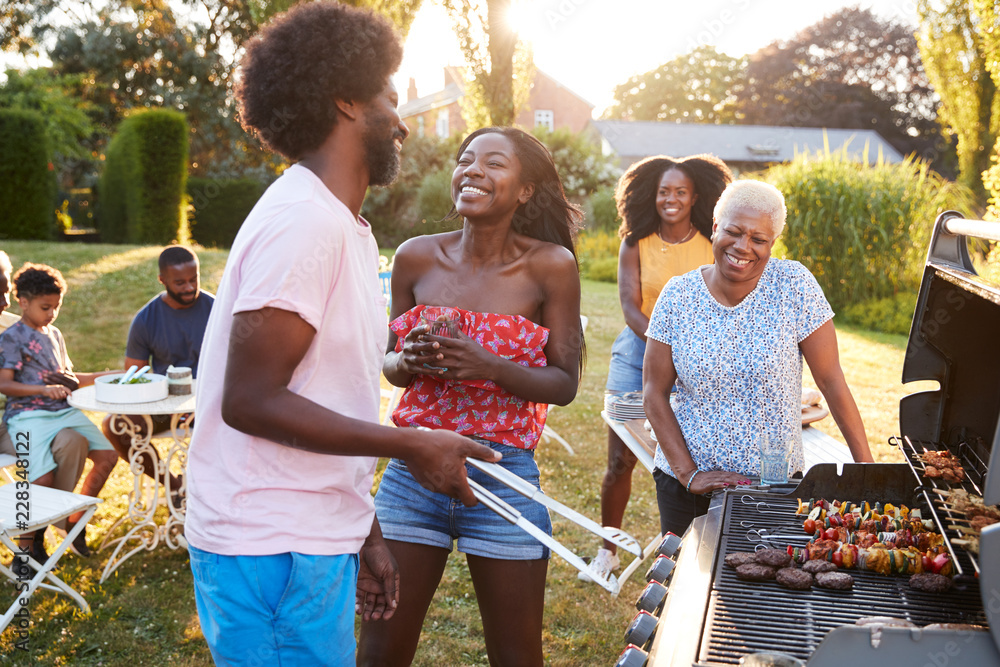 Obraz premium Couple laughing at a multi generation family barbecue