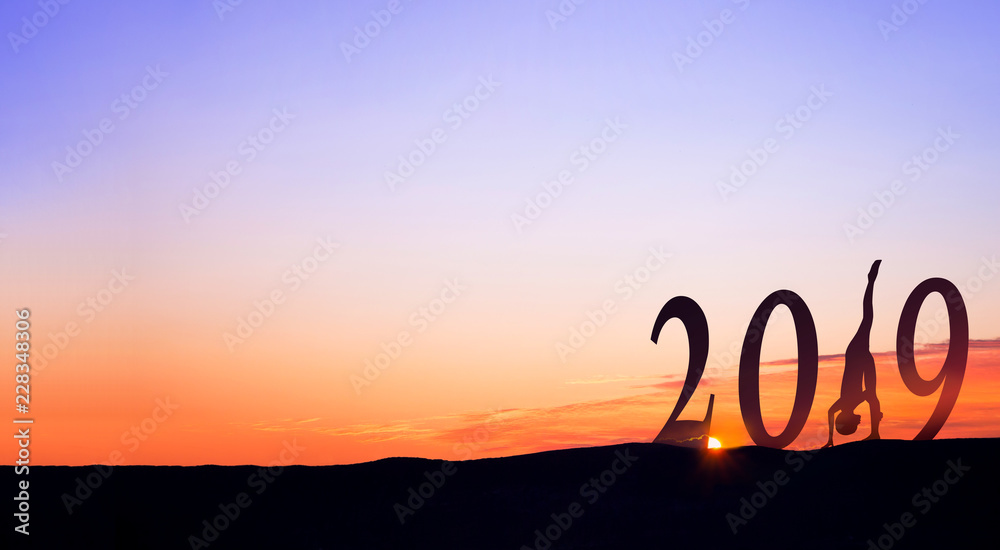 2019 On dark mountains with silhouette of a woman practicing yoga and sunrise as background. 2019 On dark mountains with silhouette of a woman practicing yoga and sunrise as background.