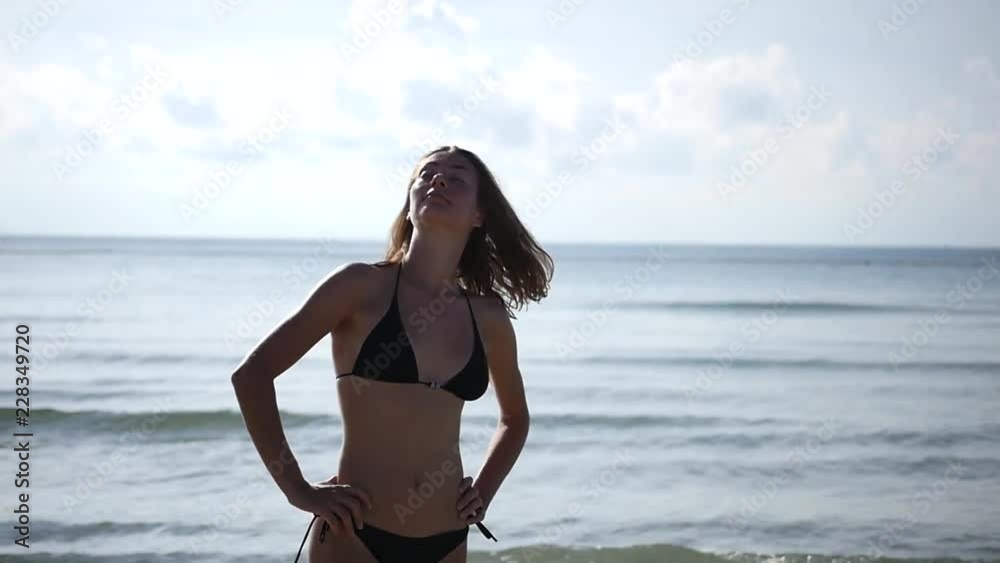 Beautiful slender girl in a bathing suit standing on the beach, spinning. enjoying the sun. HD, 1920x1080, slow motion Beautiful slender girl in a bathing suit standing on the beach, spinning. enjoying the sun. HD, 1920x1080, slow motion