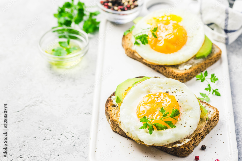 Avocado, cream cheese and fried egg sandwich. Selective focus, space for text. Avocado, cream cheese and fried egg sandwich. Selective focus, space for text.