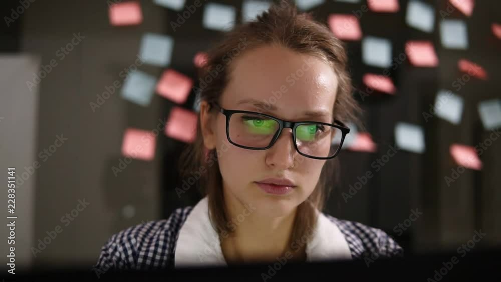 Woman with laptop. Young woman in glasses working at a laptop in the office. Business woman - office worker. Girl student to work at a computer. Search for information on the internet while sitting Woman with laptop. Young woman in glasses working at a laptop in the office. Business woman - office worker. Girl student to work at a computer. Search for information on the internet while sitting