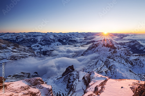 Aerial view of snow capped mountains during sunset photo