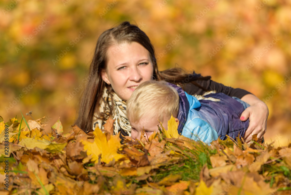 Mom and child in the fallen leaves Mom and child in the fallen leaves