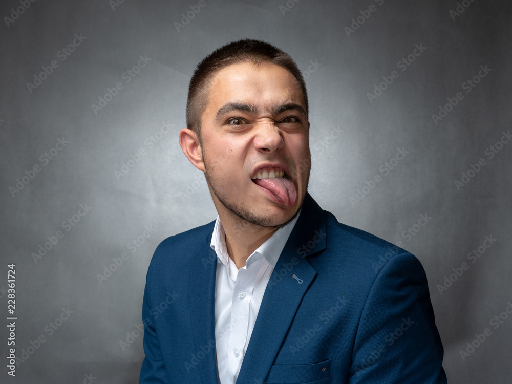 Handsome successfull businessman in blue suit sitting and showing expressions Handsome successfull businessman in blue suit sitting and showing expressions