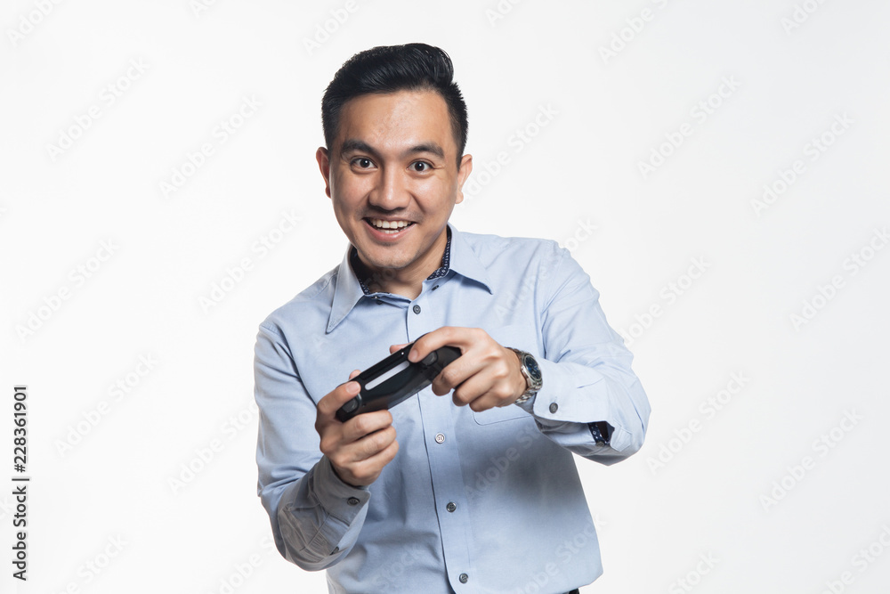 Asian man in work cloth playing console game Asian man in work cloth playing console game